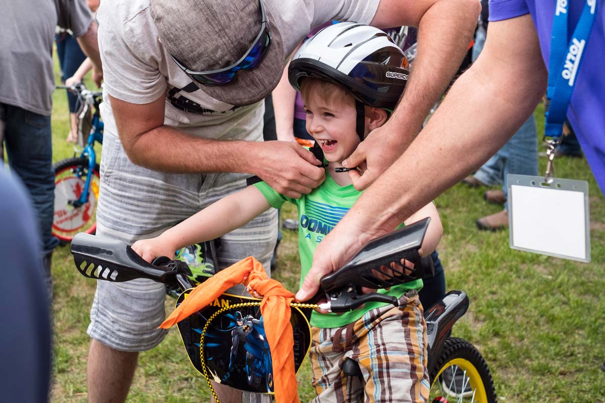 Young child happily receiving a new bike from Tolko